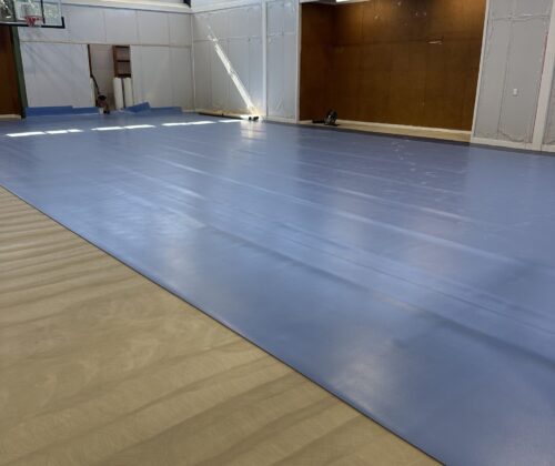 Gym flooring installation in progress—precision-laid sheets being fitted for a seamless, durable finish.